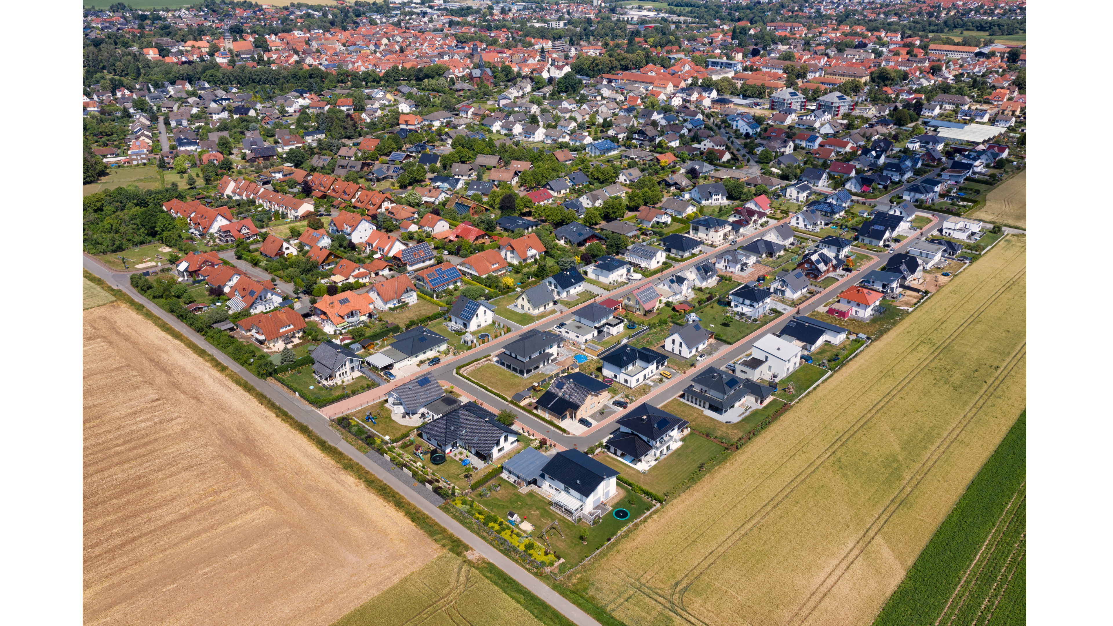Aerial view of suburban houses and green fields